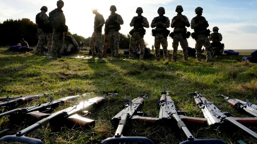 当乌克兰人员拿走武器时，武器躺在地上在英国武装部队的军事基地训练期间休息。